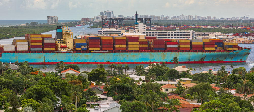 Parked cargo container ship next to a port neighborhood.